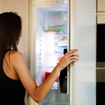 uma-jovem-abrindo-uma-geladeira